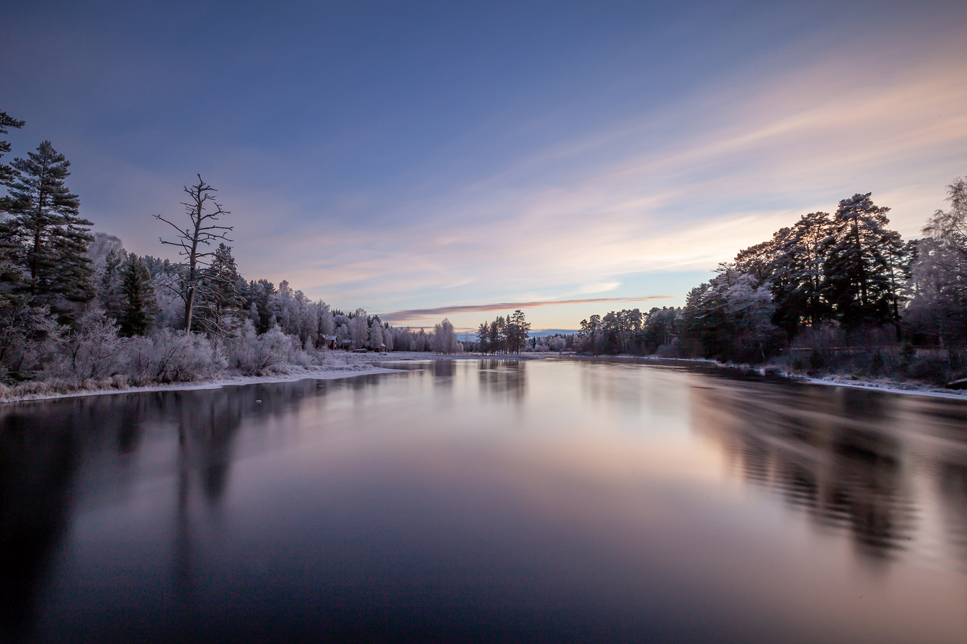 Blue hour light over a river in a Nordic landscape